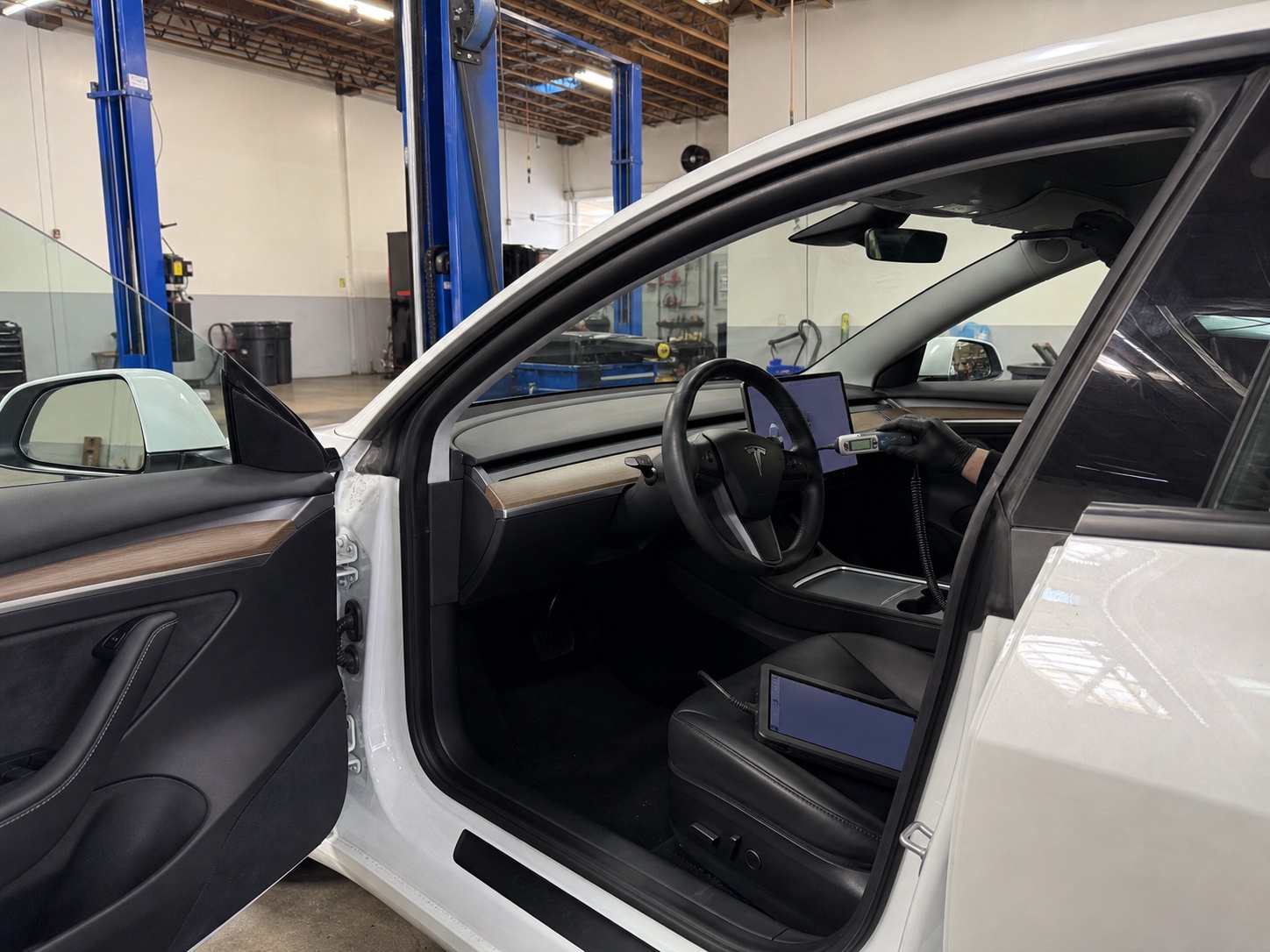 Technician checking cabin temperature during Tesla AC diagnostics